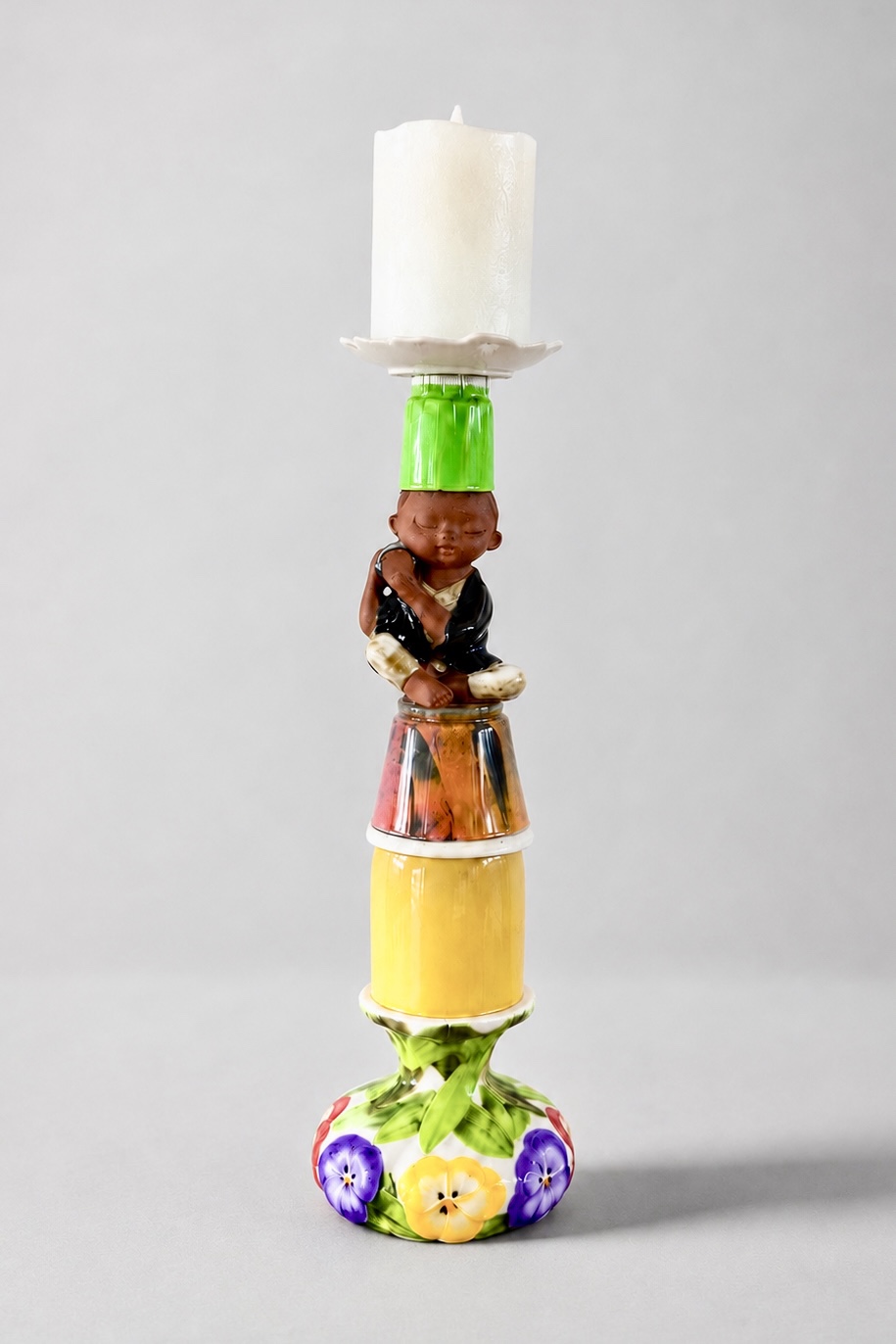 Colourful assemblage candleholder with a seated boy holding a drum