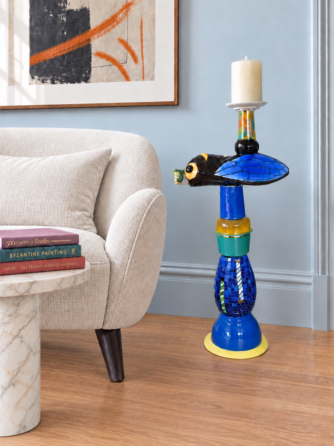 Blue sculptural candleholder with a fly and frog in a room setting