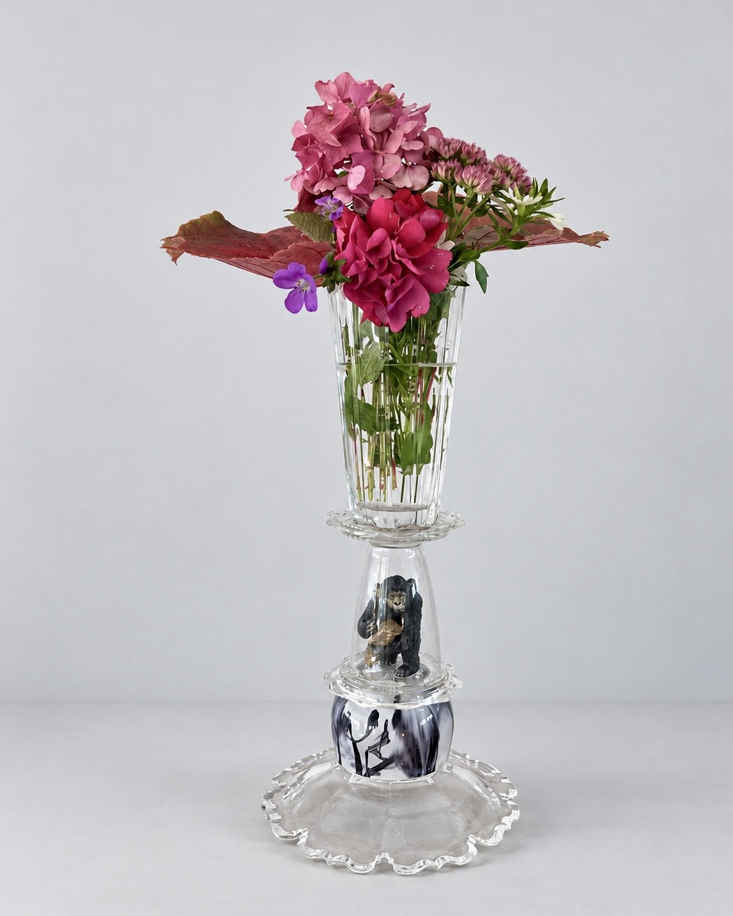Gorilla glass assemblage holding flowers; original view showing the gorilla's face