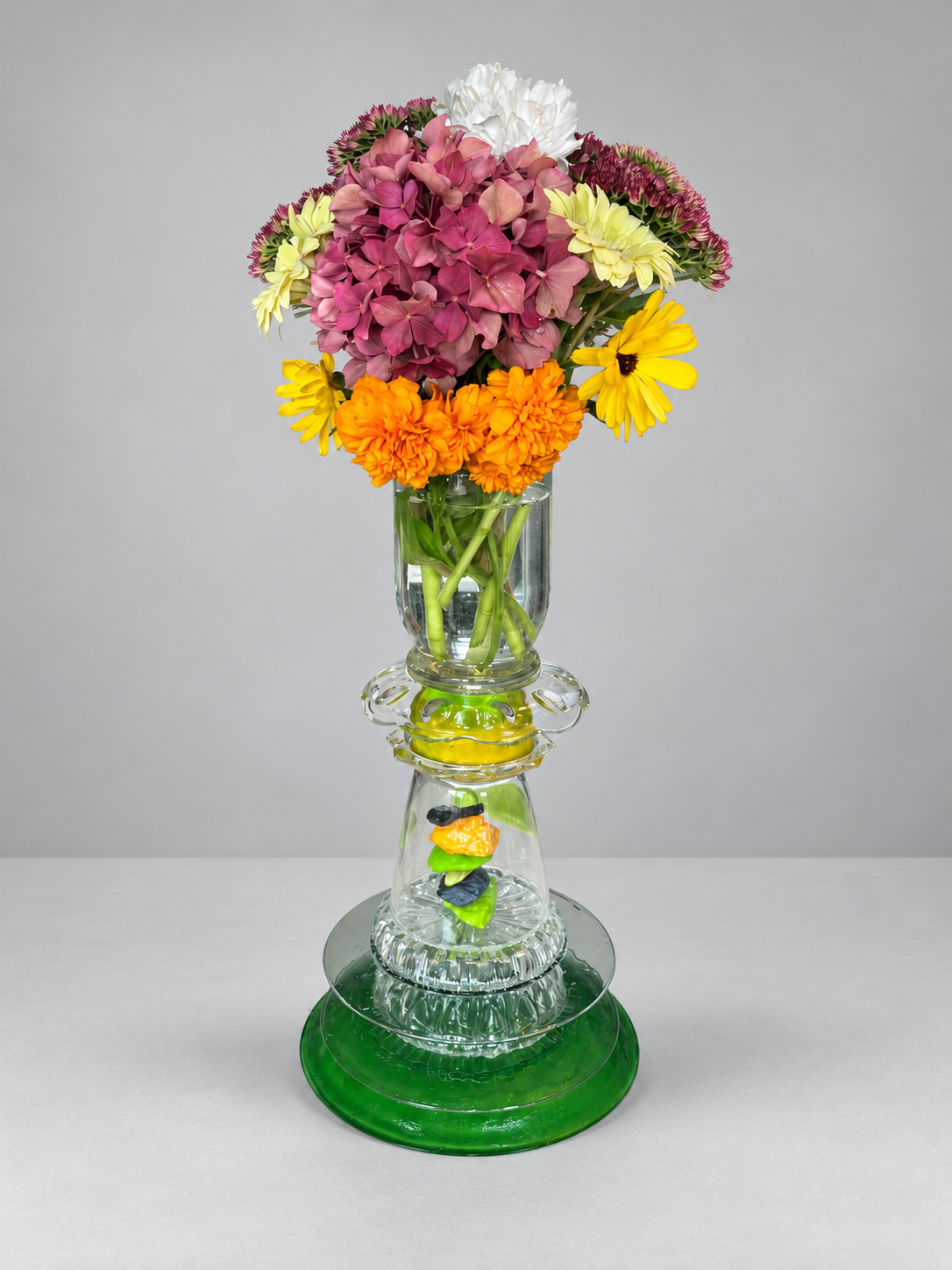 Green glass assemblage used as a vase with flowers