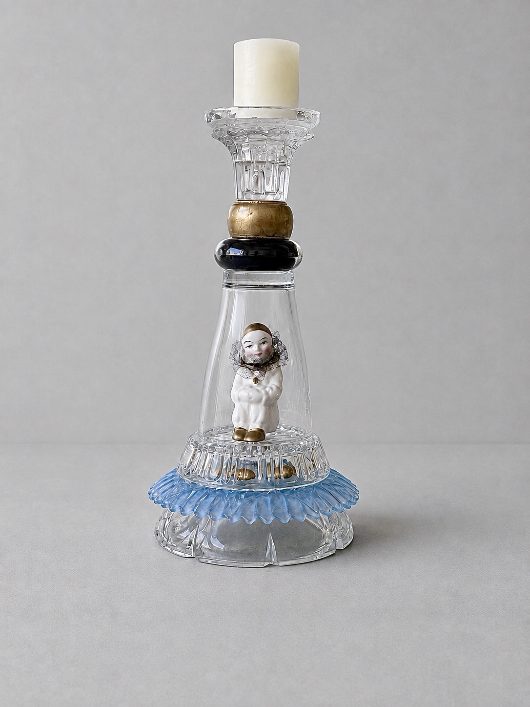 Pantomime figure held inside a clear glass assemblage with blue details