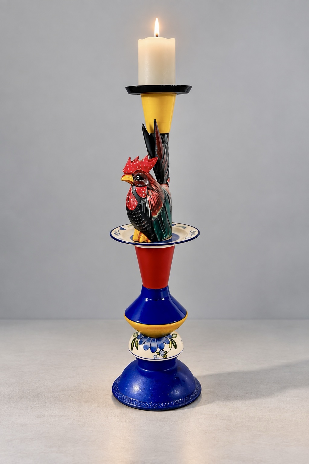 Complete colourful rooster assemblage candleholder on a pale grey background